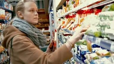 年轻女子在超市挑选食物，她检查每个产品的包装